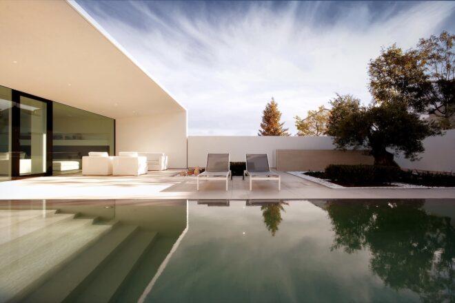 pool in foreground and lounge chairs on a patio in background