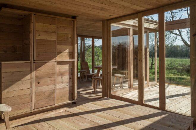 lightly hued timber tiny cabin with sliding glass doors