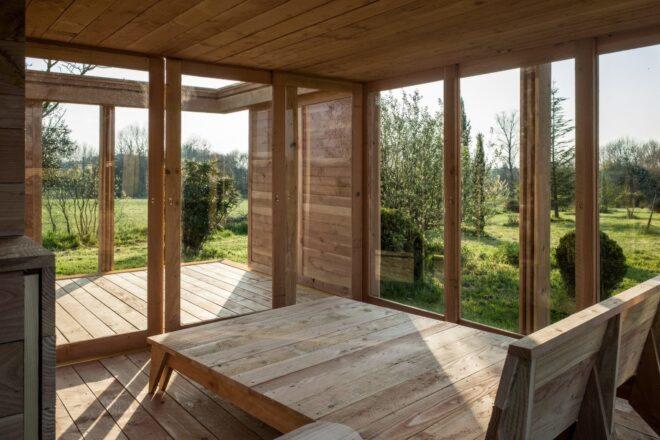 room with walls of glass and wood platform bed