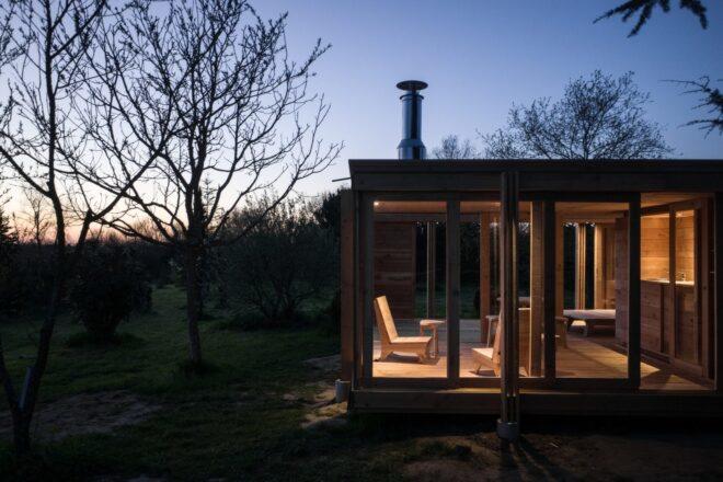 evening shot of tiny home with all glass walls