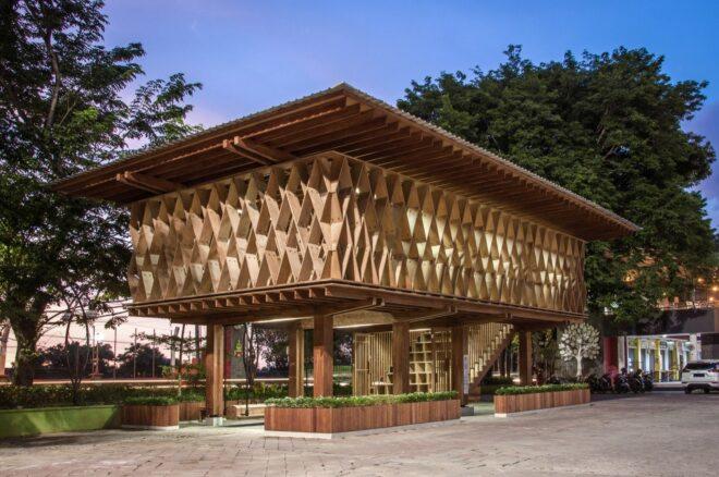 an elevated wooden library lit up in the evening