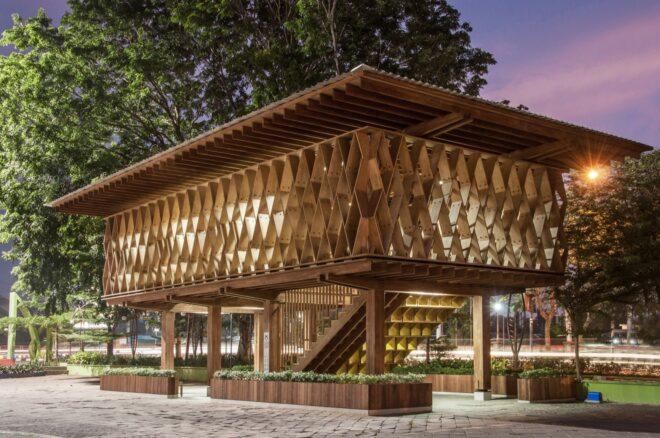 an elevated wooden library lit up in the evening