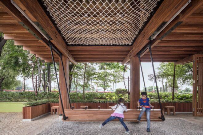 two kids playing under an elevated wooden building