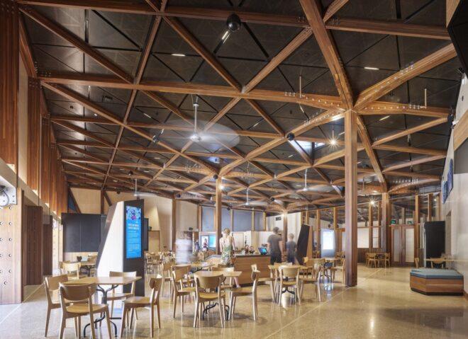 tables and chairs under wood ceiling with a pattern resembling a turtle shell