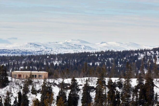 wood cabin on snowy, mountainous landscape