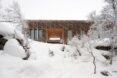 wooden cabin nearly covered in fluffy snow