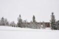 expansive, snowy landscape with cabin on the horizon