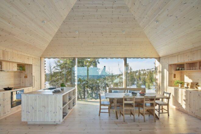 all-wood interior space with large windows, wood dining table and wood kitchen island