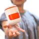 a person with a white and orange PICO pod hovering above their hand