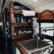 a kitchen with wooden shelving next to a large sink
