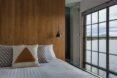 white bed with patterned pillows next to a large window