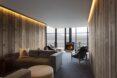 modern living area in a hotel room with gray sofa and wood-burning stove