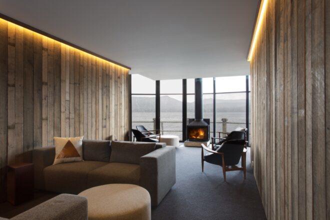 modern living area in a hotel room with gray sofa and wood-burning stove
