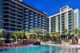 hotel with large pool surrounded by palm trees