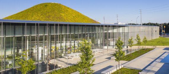 glass building with a hilly green roof