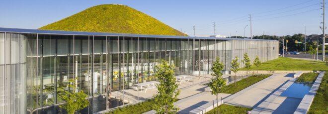 glass building with a hilly green roof