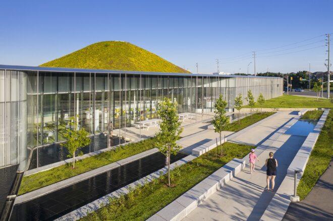 glass building with a hilly green roof
