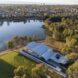 aerial view of lakeside community center with white wavy roof