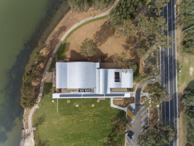 aerial view of large community center with white roof and solar panels