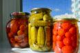 three cans of pickled tomatoes, cucumbers and radishes