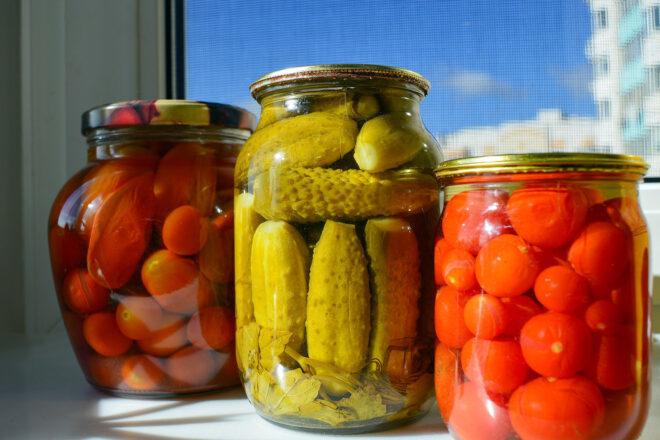 three cans of pickled tomatoes, cucumbers and radishes