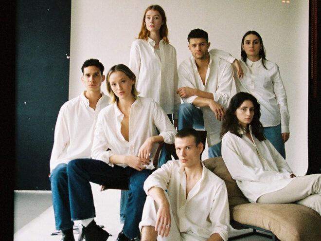 several models in white button-down shirts and jeans