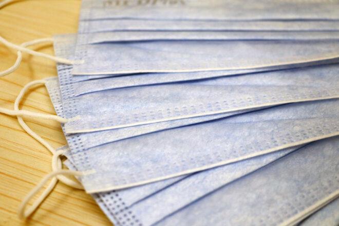 several blue paper masks on wood table