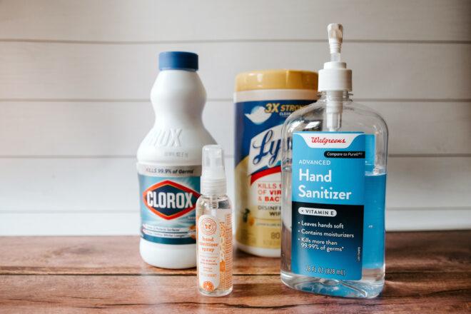 bleach, disinfecting wipes and hand sanitizer on wood table