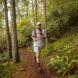 person running on a hiking trail in a forest