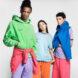 three people layered in bright T-shirts, sweatshirts and sweatpants