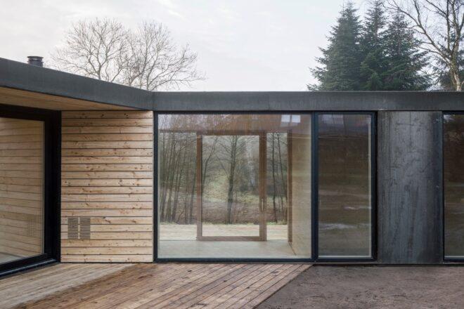 wood patio near a wood home with large glass windows