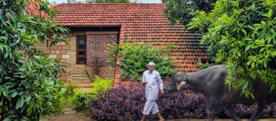 person walking near tan home with terracotta roof