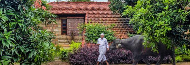 person walking near tan home with terracotta roof