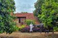 person walking near tan home with terracotta roof