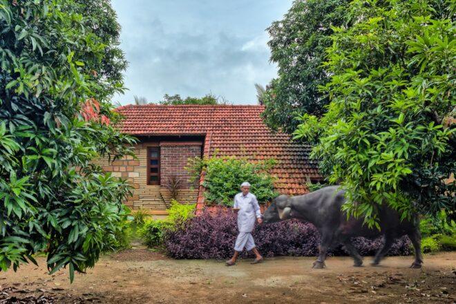 person walking near tan home with terracotta roof