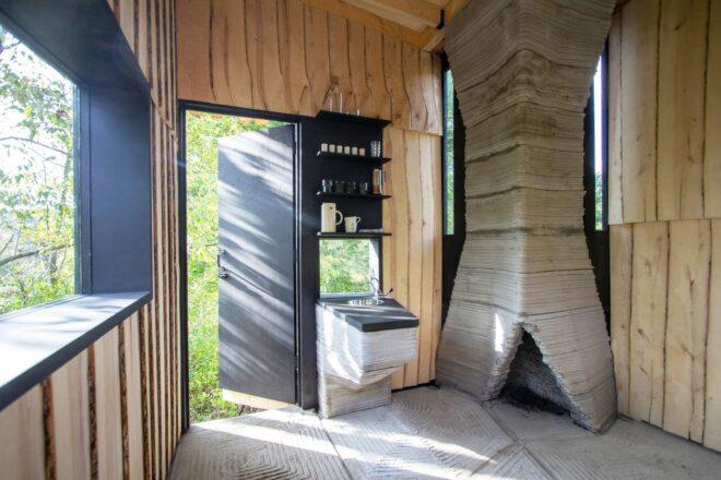 wood cabin interior with large concrete chimney