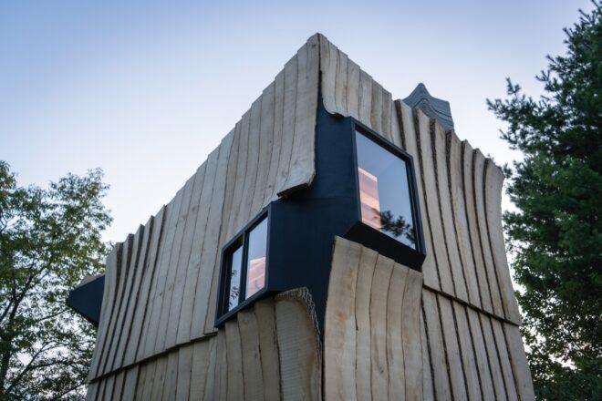 exterior of cabin with curved sections jutting out from frame