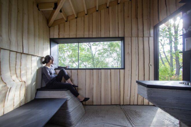 woman sitting in the corner looking out of horizontal window