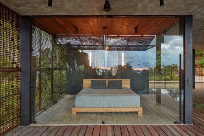 large gray bed in a room with glass walls