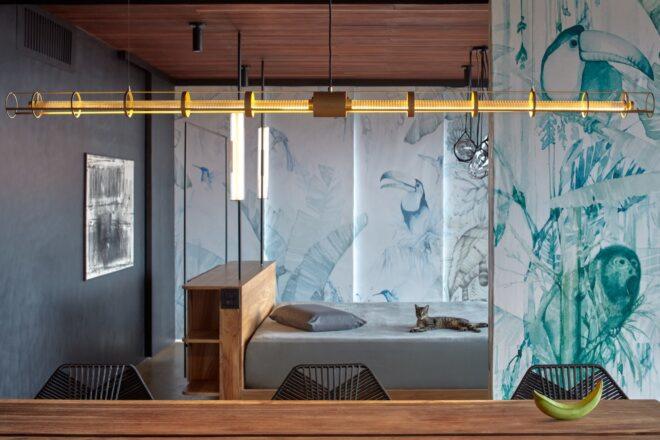 glass wall with a bed on one side and a wood dining table on the opposite side