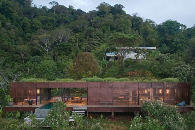 weathered steel and dark timber building with green roof