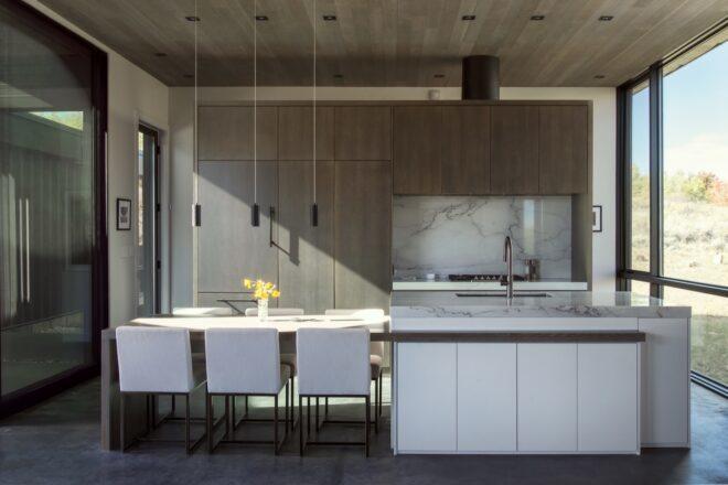 long white kitchen island with white dining chairs