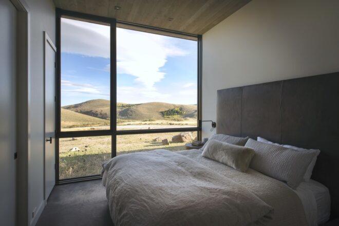 large fluffy white bed near wall of glass