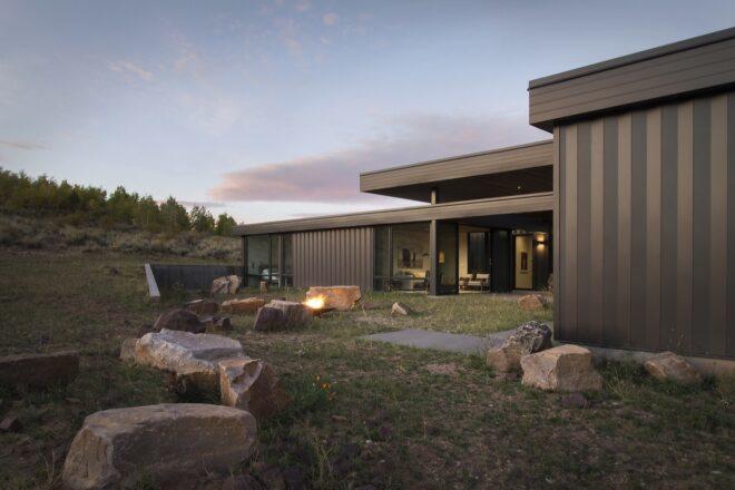 dark home with large backyard with rock seats and a fire pit