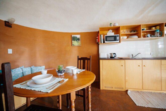 wood dining table beside a kitchen with wood cabinets