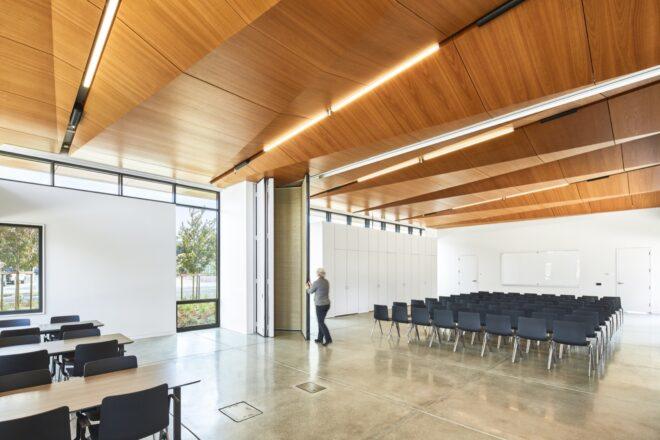 several chairs in a large white room with a wood ceiling