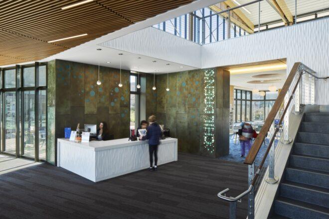 person at white reception desk with a wall that reads "Children's"