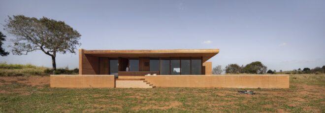 long rammed earth home in an open, grassy landscape
