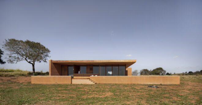 long rammed earth home in an open, grassy landscape