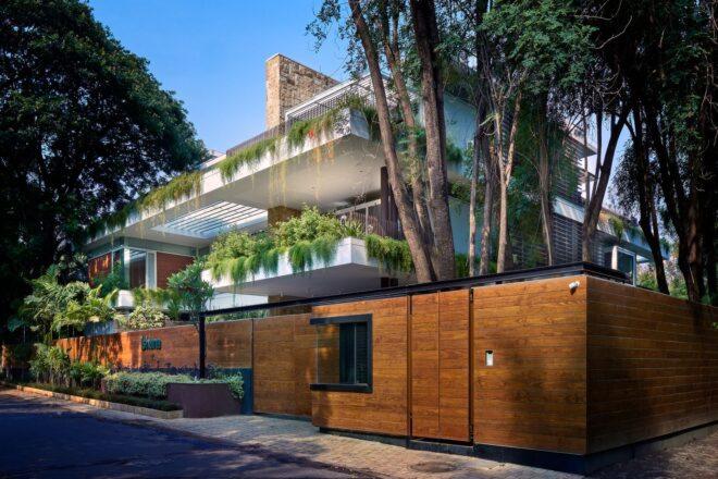 street view of home with large balconies covered in greenery